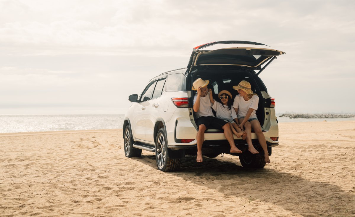 Family on a road trip with their van stopped by the water